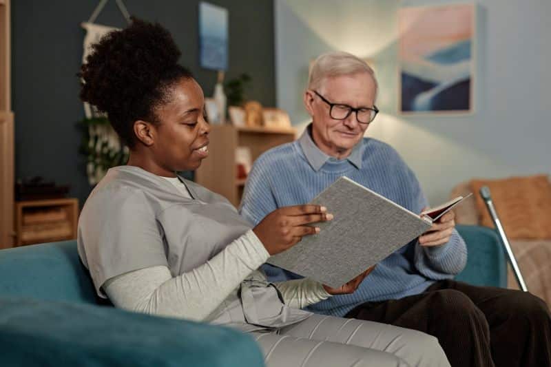 Nurse looking through photo album with patient